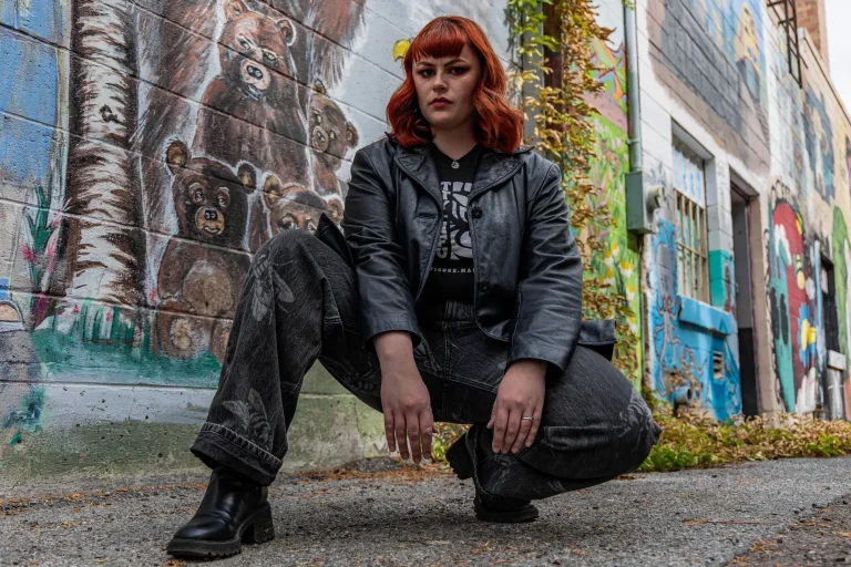 Manticore Marketing team member crouching in front of a street mural