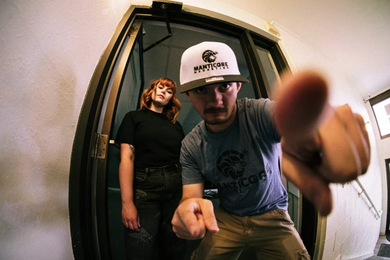 Manticore Marketing team pointing at the camera in an elevator, fisheye